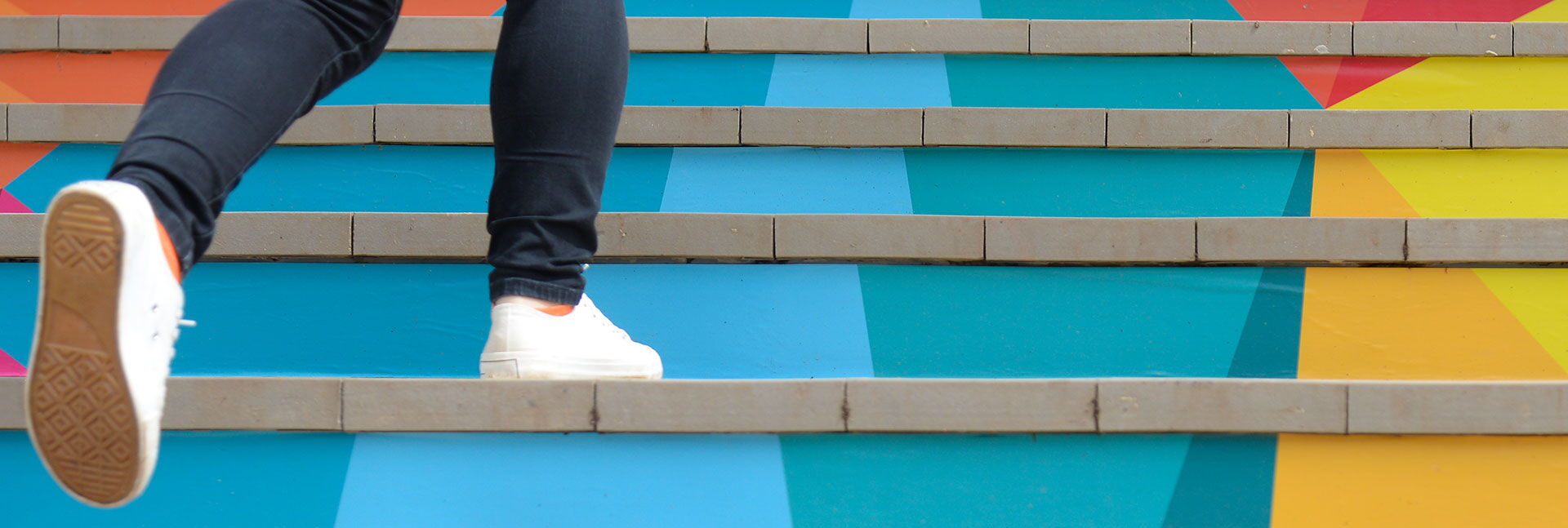 Person geht Treppe nach oben, Symbol für persönliche Entwicklung, Karrierefortschritt und Führungskräfteentwicklung.